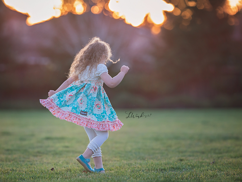 young girl twirling in the grass