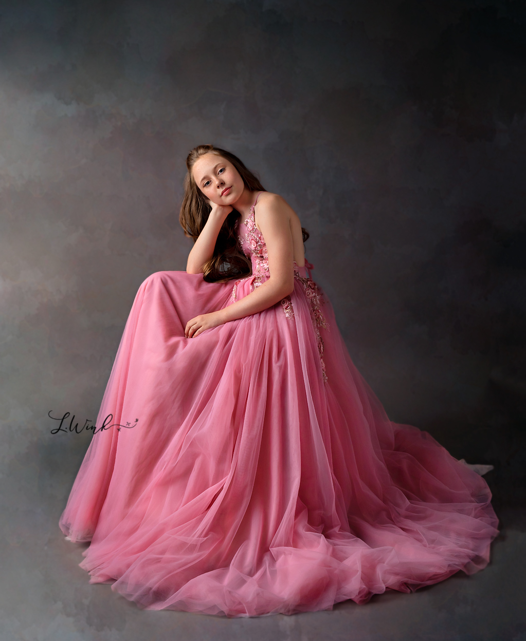 young girl sitting in a pink couture princess gown
