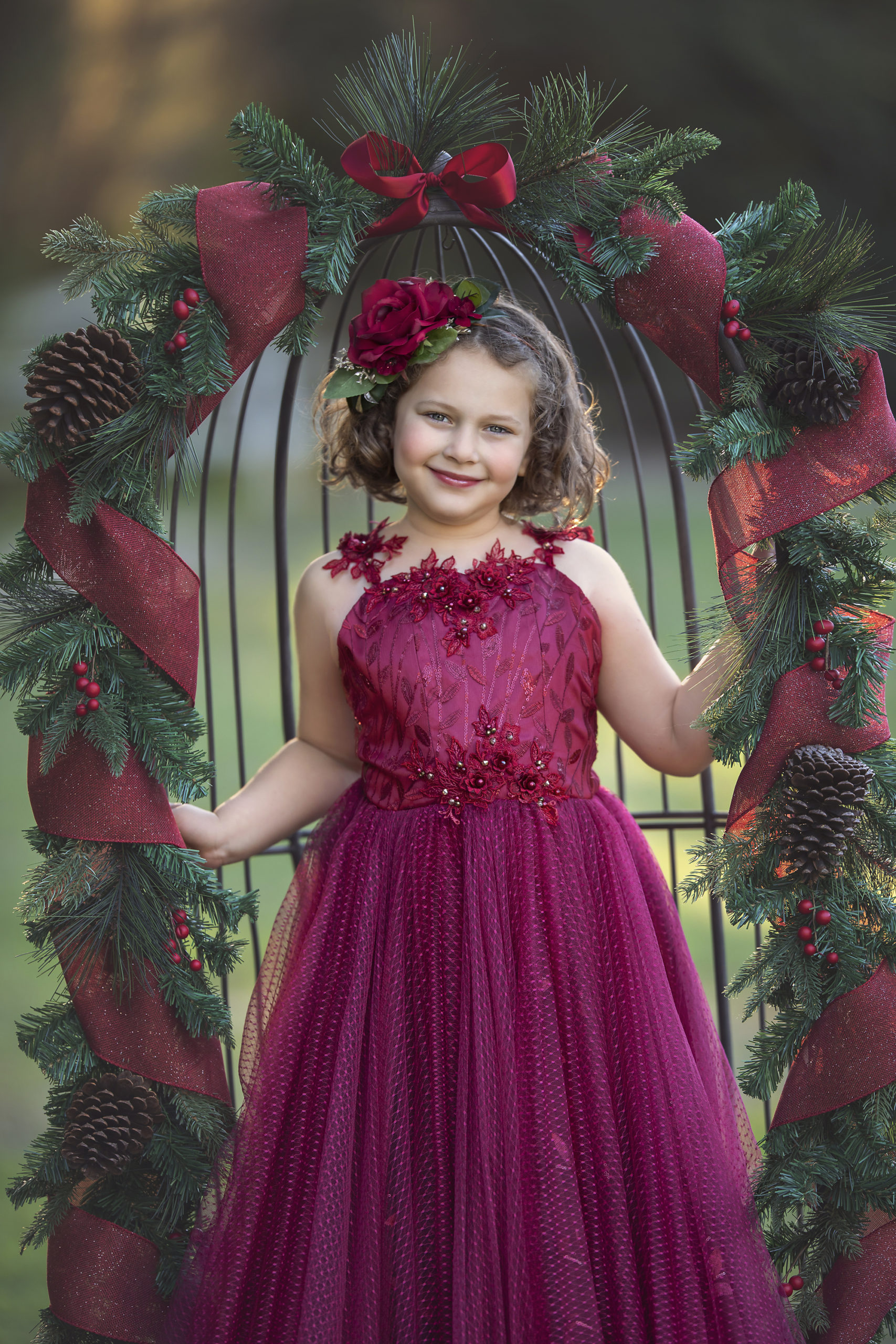 Girl in red dress under Christmas garland