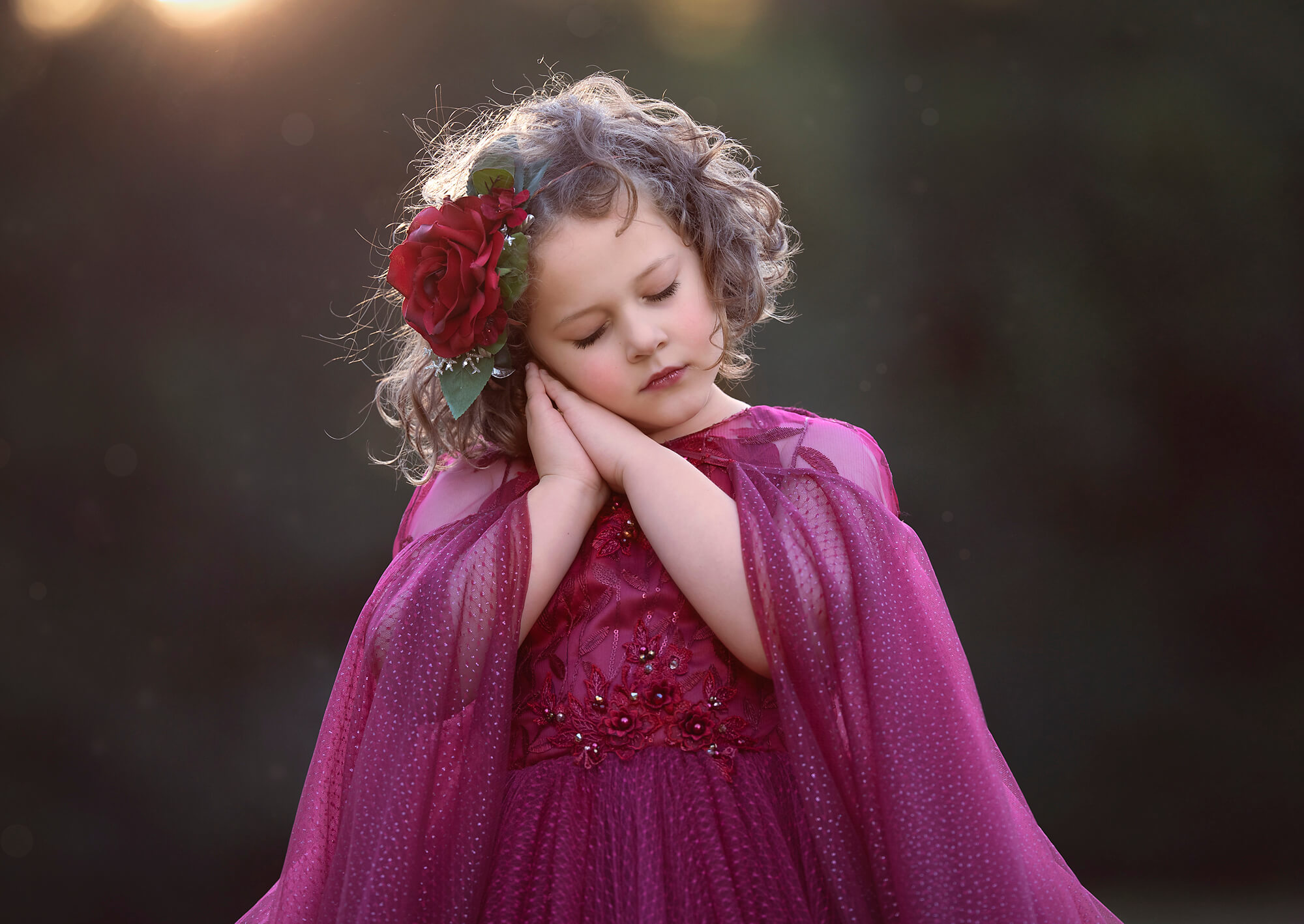 Girl resting cheek on hands in pink dress at Chandler Park, California