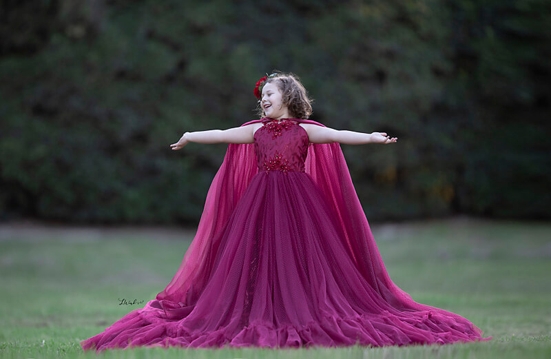 Young girl in magenta dress standing in Los Angeles park