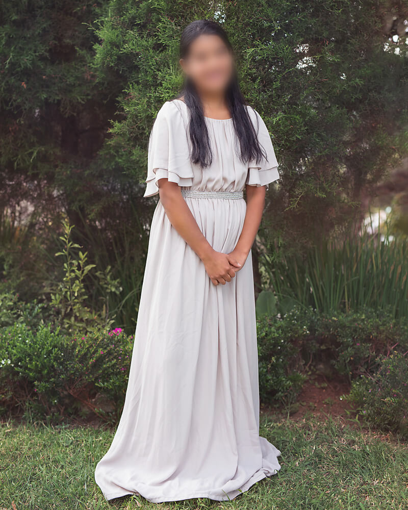 Teenage girl standing in gray dress