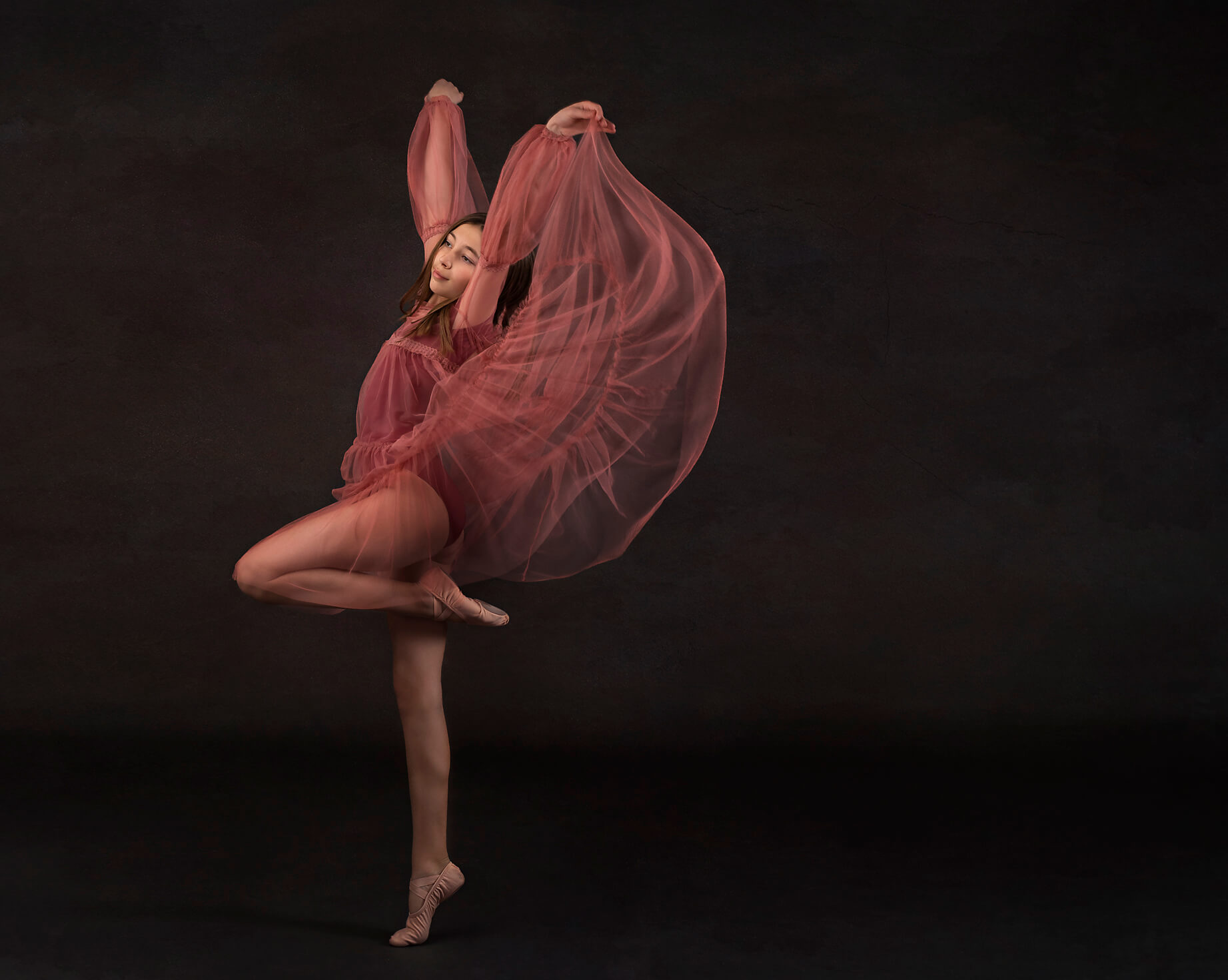 Young girl in ballet shoes and pink dance dress
