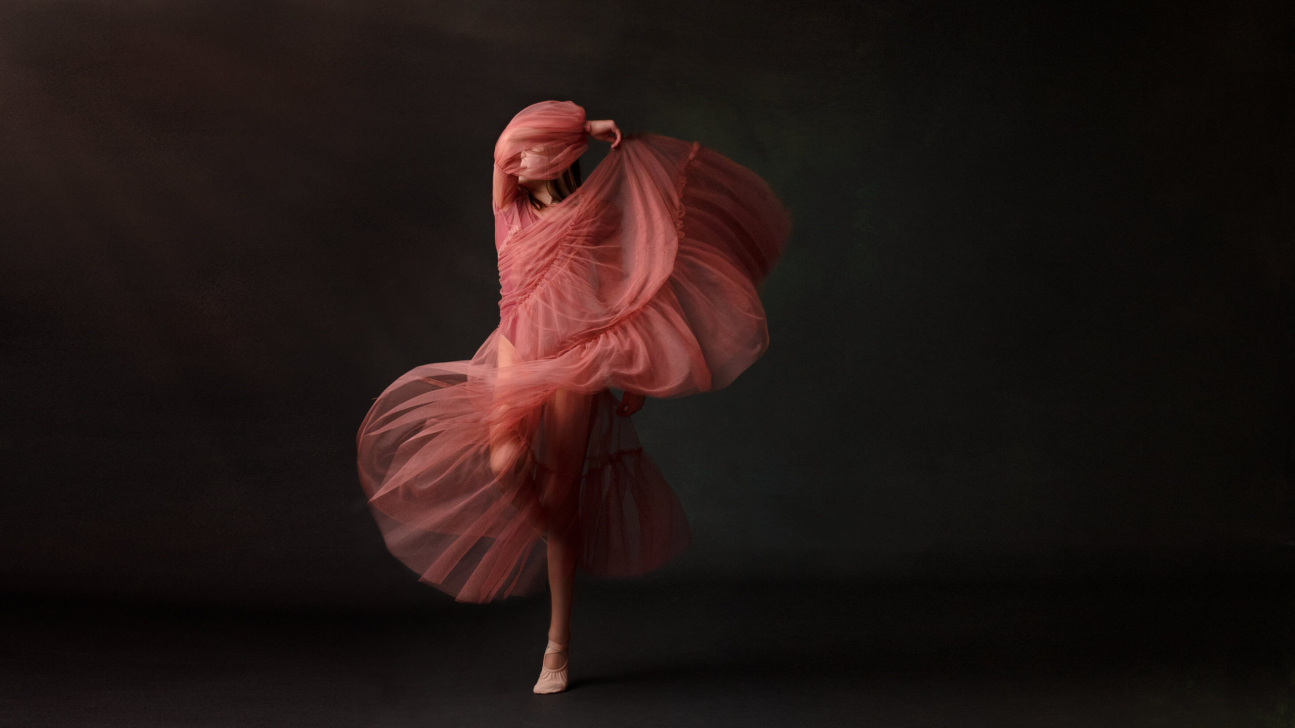Girl twirling in California photo studio in pink dress