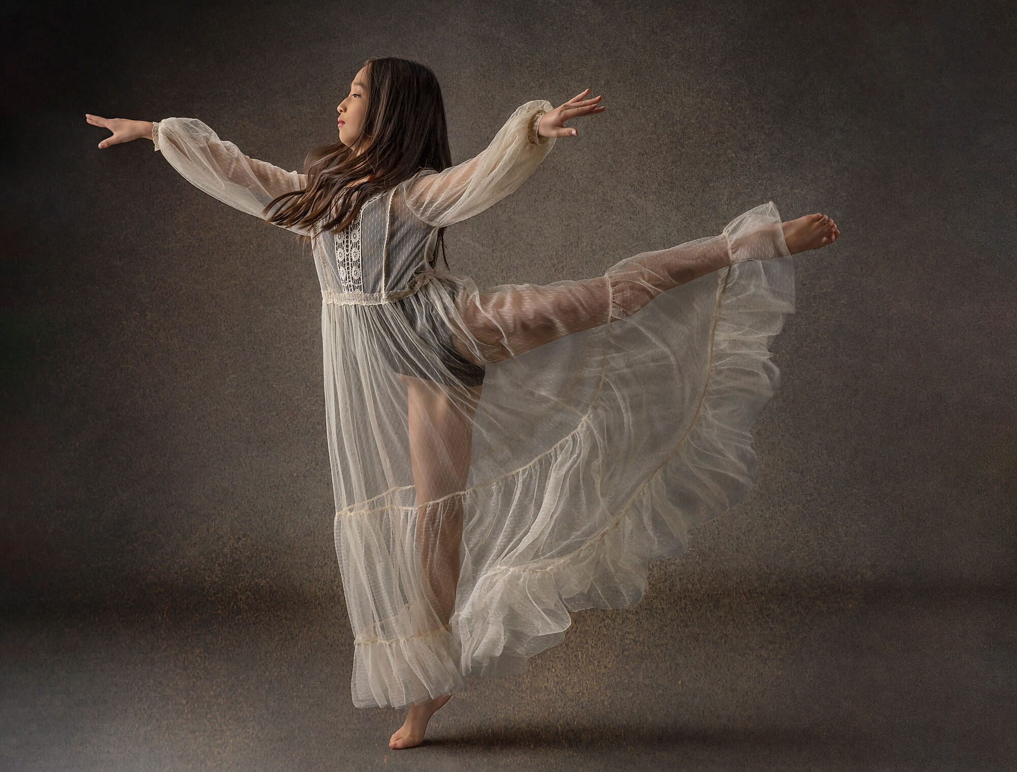 Torrance dancer in arabesque pose wearing a cream dress