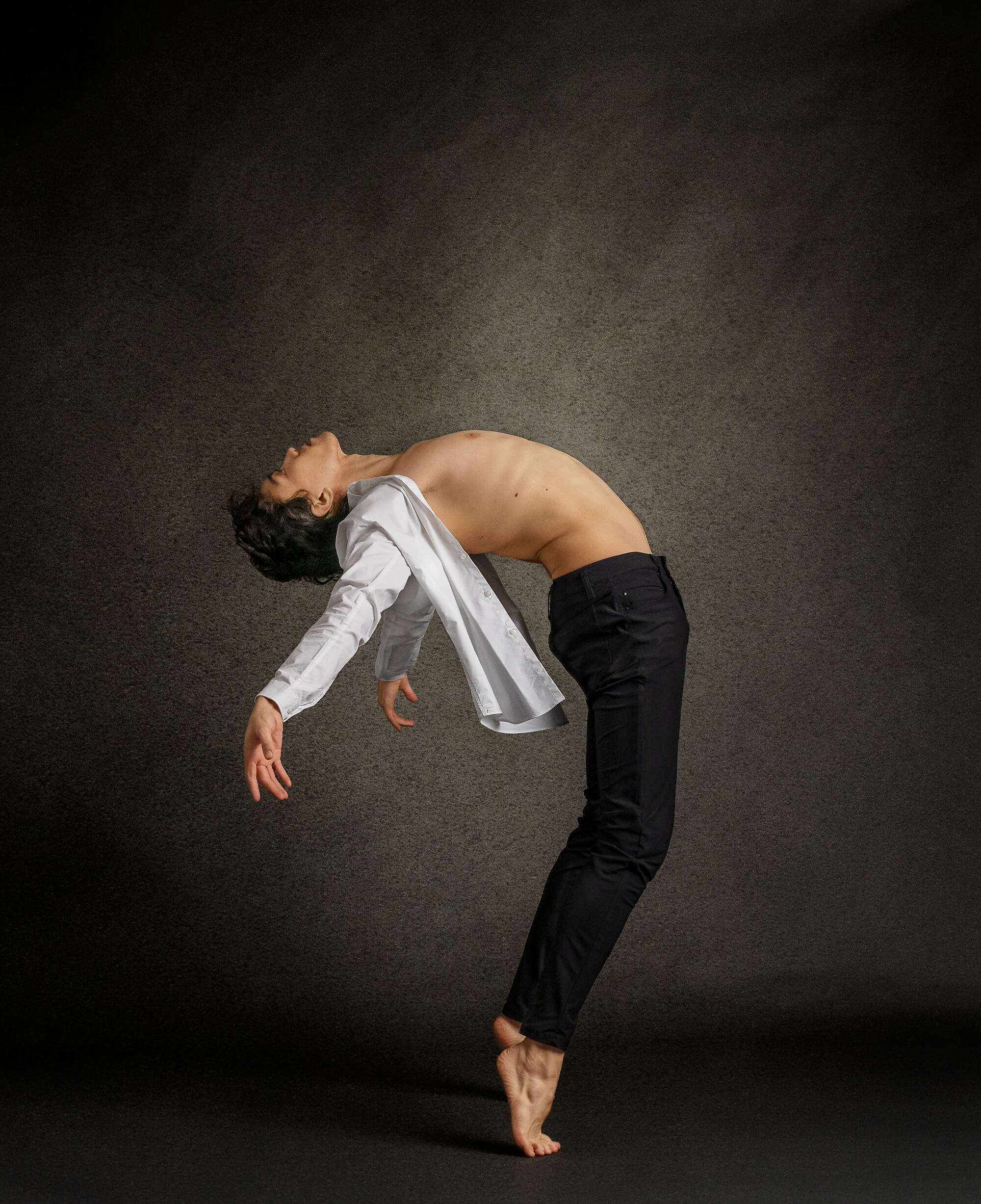 Dancer posing throwing arms back in CA photo studio