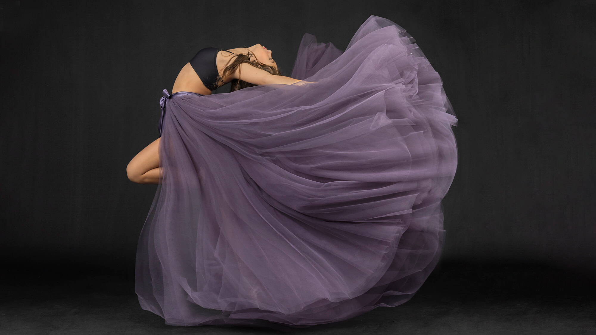Teen dancer arching back in purple skirt