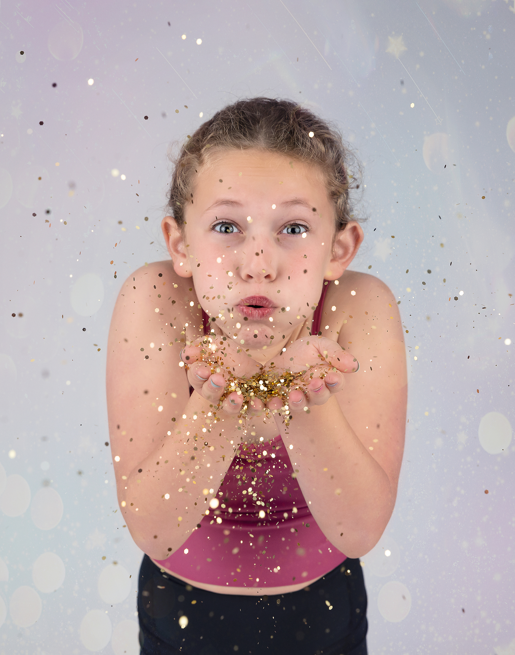 child blowing gold glitter portrait